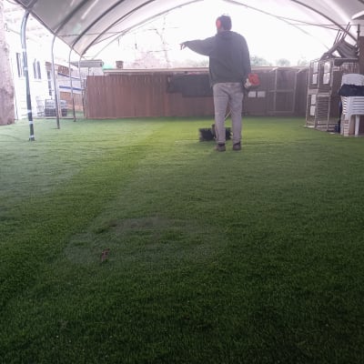 אדם עם אוזניות עומד על דשא מלאכותי