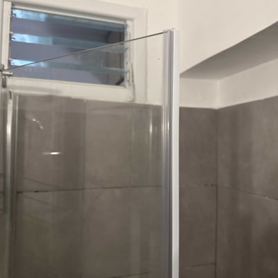 זכוכית מקלחון עם קיר אריחים וחלון קטן