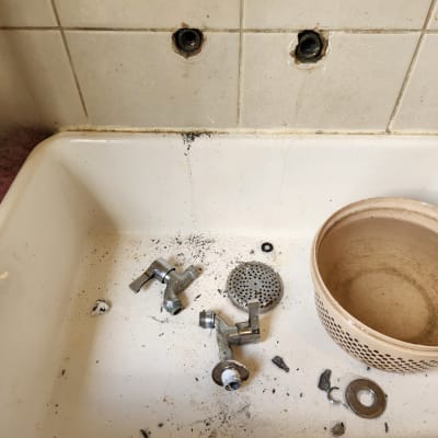 כיור עם חלקי ברז מפורקים וכלי עבודה