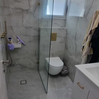 מחיצת זכוכית במקלחת עם חלון קטן