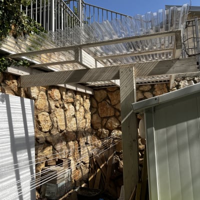 גג פלסטיק שקוף על קורות עץ בגינה