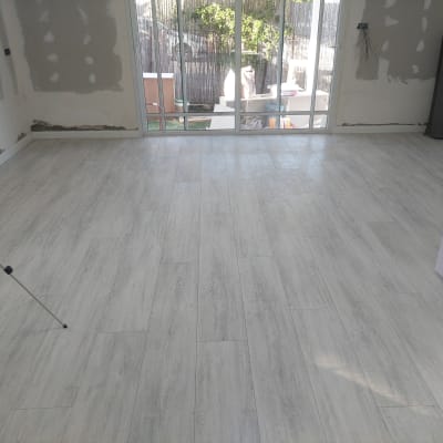 רצפת פרקט בהירה בחדר ריק עם קירות לא גמורים