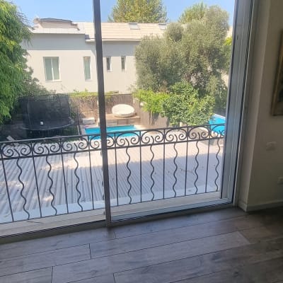 חלון זכוכית גדול עם נוף לחצר ובריכה