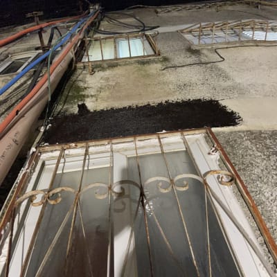 איטום קיר חיצוני עם חומר שחור ליד חלון