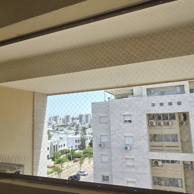 רשת יונים מותקנת במרפסת בניין מגורים