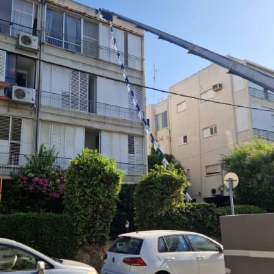 מנוף מרים חפץ לגג בניין מגורים