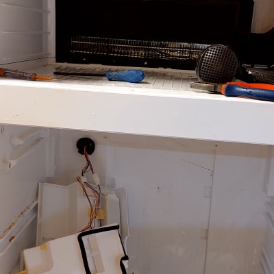 תיקון מקרר עם כלים וחלקים פנימיים חשופים