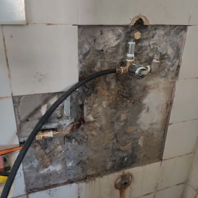 צינור מים מחובר לקיר עם ברז וחיבורים