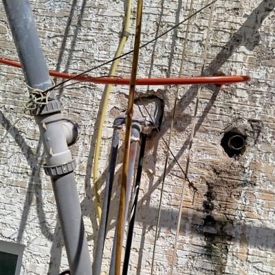 צינורות וחבלים על קיר לבנים, עבודה בגובה