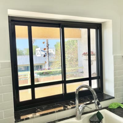 חלון אלומיניום שחור במטבח עם כיור וברז