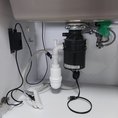 כיור מטבח עם מערכת סילוק אשפה וצינורות חיבור