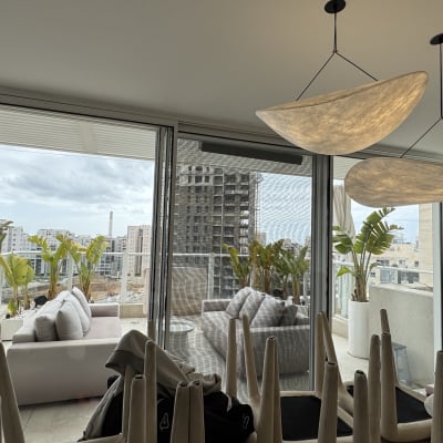 מרפסת עם צמחים ונוף עירוני ברקע