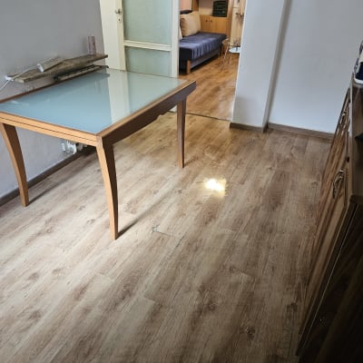 רצפה נקייה עם שולחן זכוכית וחדר מגורים ברקע