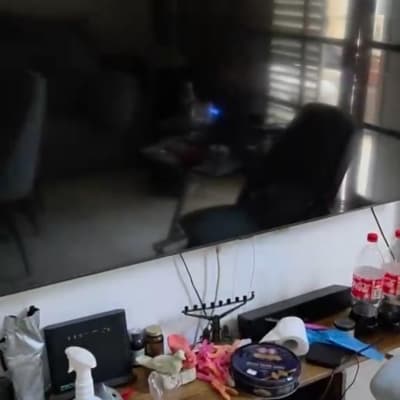 טלוויזיה על קיר עם שולחן קטן וחפצים שונים