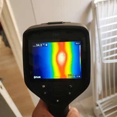 מד חום תרמי מציג אזור חם על הקיר