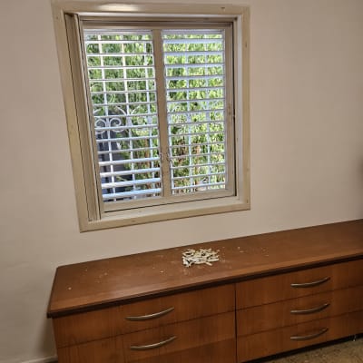 חלון עם תריסים ומגירה עם שאריות חומר