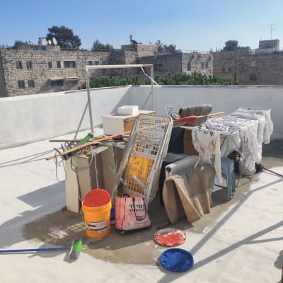 דלי כתום עם מכסה כחול על גג לבן