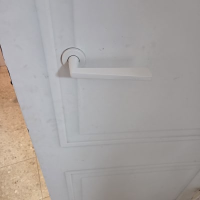 ידית דלת לבנה על דלת לבנה