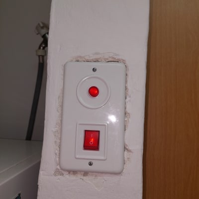 מתג חשמלי עם נורית חיווי אדומה בקיר