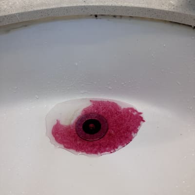 כיור עם כתם צבע ורוד סביב הניקוז