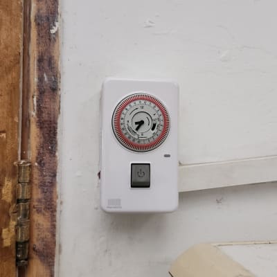 שעון טיימר חשמלי מותקן על קיר לבן