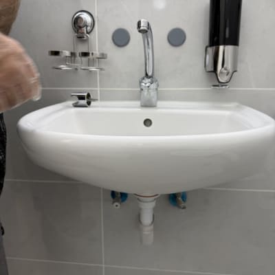 כיור עם ברז ומתקן סבון בחדר אמבטיה