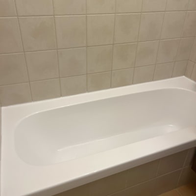 אמבטיה לבנה עם חיפוי קיר אריחים בהירים