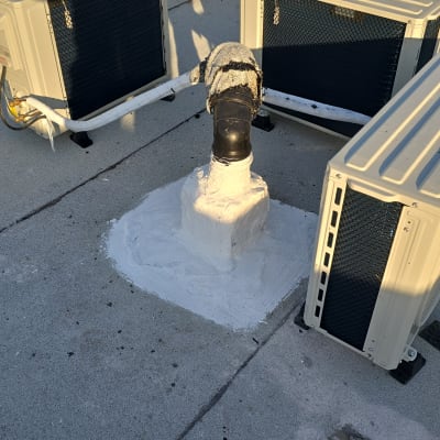 צינור אטום בחומר לבן על גג בטון