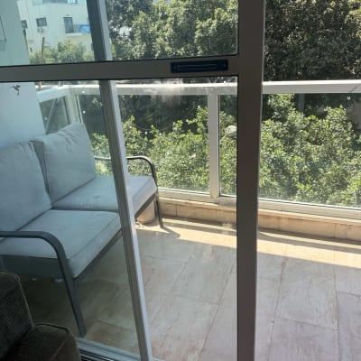 דלת הזזה מזכוכית ומעקה זכוכית במרפסת דירה