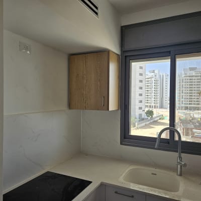 מטבח חדש עם כיור וברז, ארונות ועיצוב מודרני