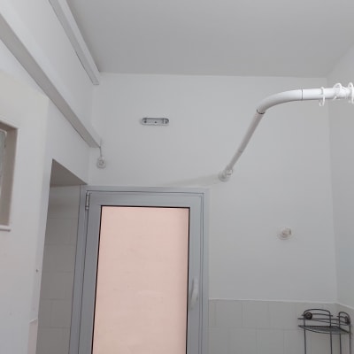 קיר ותקרה צבועים בלבן עם צינור לבן