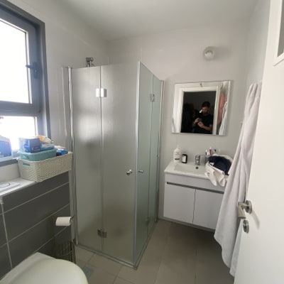 מקלחון זכוכית עם דלתות מתכת בחדר אמבטיה