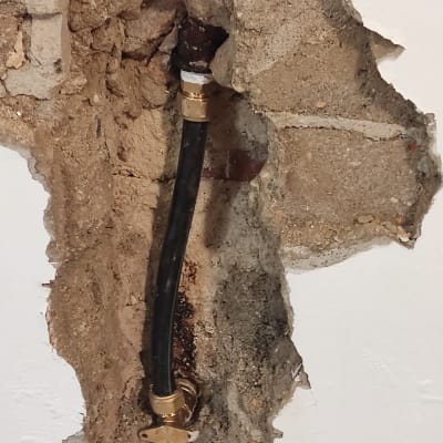 צינור שחור עם מחברים בקיר חשוף