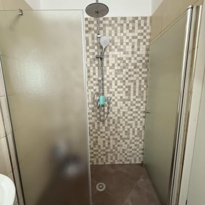 מקלחת עם ראש מקלחת ודלת זכוכית