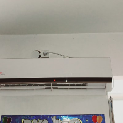 מזגן קיר לבן מותקן על קיר עם חיבור חשמלי