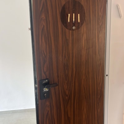 דלת עץ עם מספר 3 ומנעול שחור