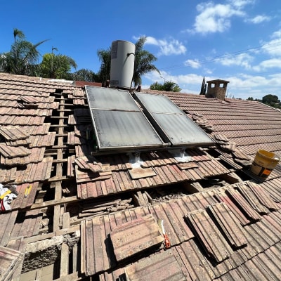תיקון גג רעפים עם דודי שמש וכלי עבודה