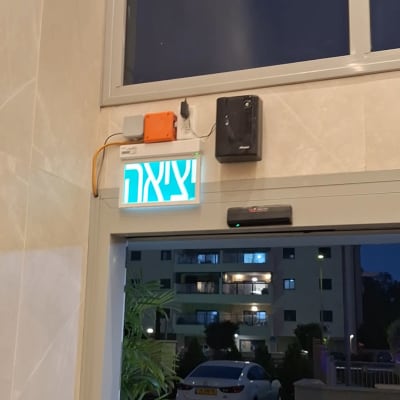 שלט יציאה עם חיווט חשמלי ליד דלת