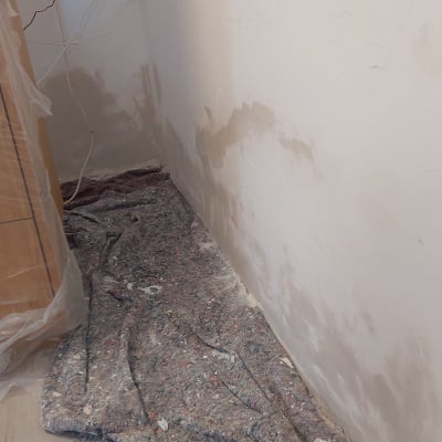 קיר עם תיקוני צבע ויריעת מגן על הרצפה