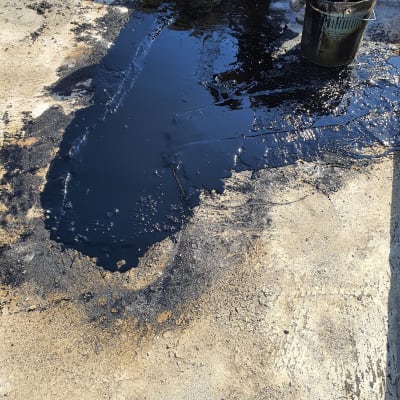 מריחת חומר איטום על גג עם מברשת ודלי