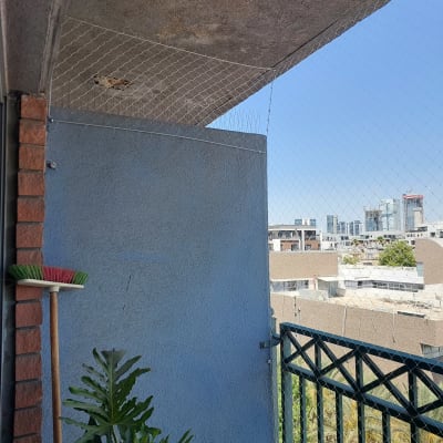 רשת יונים מותקנת על מרפסת למניעת כניסת יונים