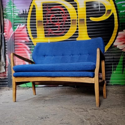 ספה כחולה עם ריפוד על רקע גרפיטי צבעוני