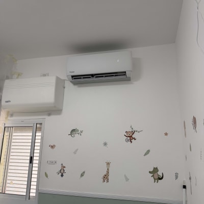 מזגן מותקן על קיר עם ציורי חיות בחדר ילדים