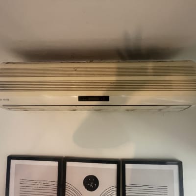 מזגן קיר מותקן על קיר לבן עם שלט דיגיטלי