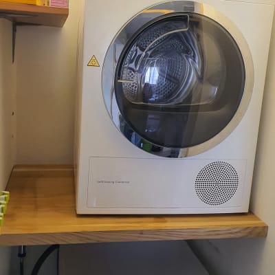 מכונת כביסה ומייבש על מדף עץ