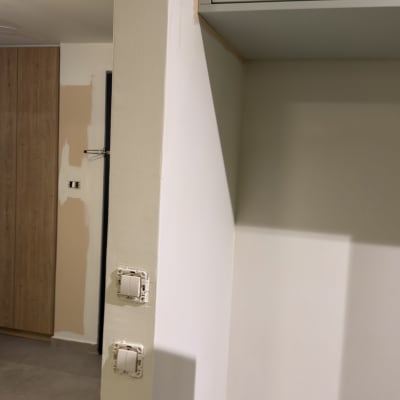 קיר צבוע עם מתגי חשמל וחלקים לא גמורים