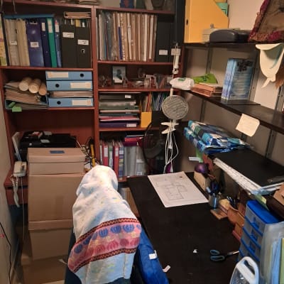 מדפים עם קלסרים, קופסאות וציוד משרדי בחדר עבודה