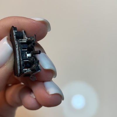 רכיב אלקטרוני קטן מוחזק ביד עם ציפורניים לבנות