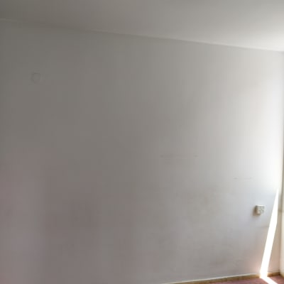 קיר לבן עם סימני צבע על שטיח ורוד