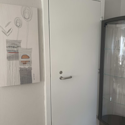 ציור מופשט על קיר ליד דלת לבנה